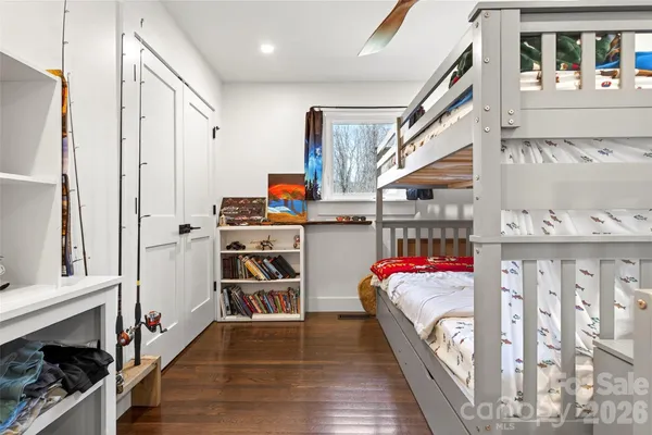 a hallway with white cabinets and wooden floor