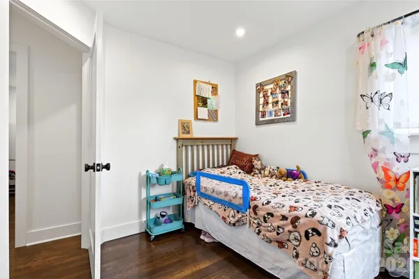 a bedroom with bed and wooden floor