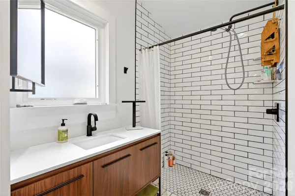 a bathroom with a sink a mirror and shower