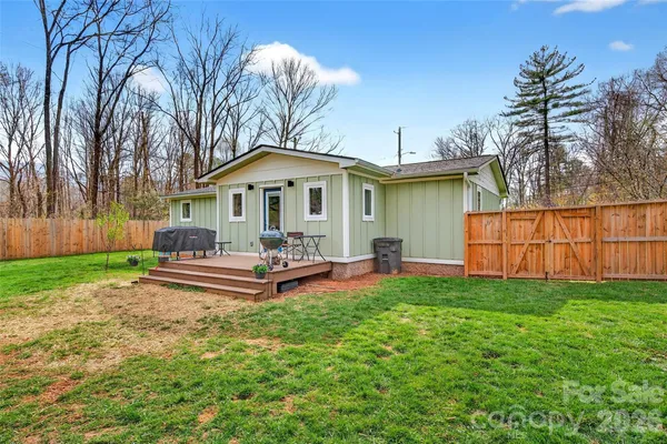 a view of a backyard with a small cabin and wooden fence