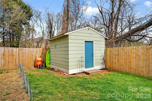 a view of backyard with potted plants and wooden fence