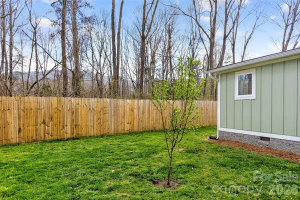 a view of backyard with wooden fence