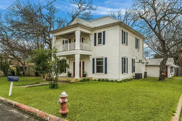 a front view of house with yard and green space