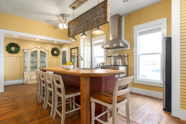 a dining room with furniture a chandelier and wooden floor