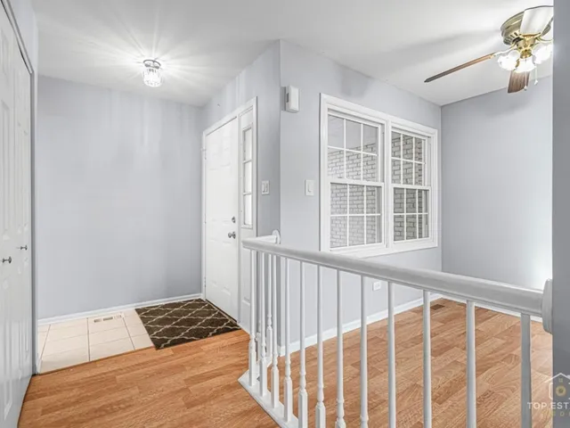 a view of a bedroom with wooden floor and windows