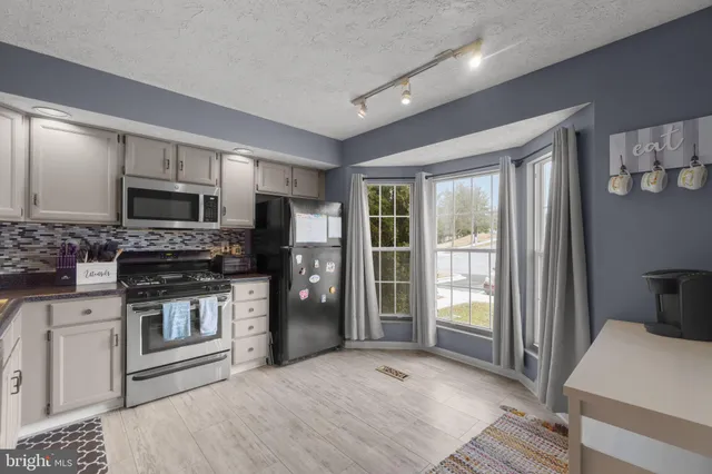 a kitchen with stainless steel appliances granite countertop a refrigerator stove and sink