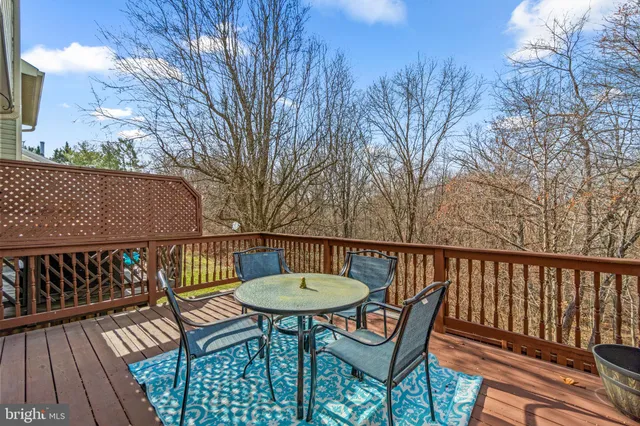 a view of a backyard with wooden fence and a couple of chairs