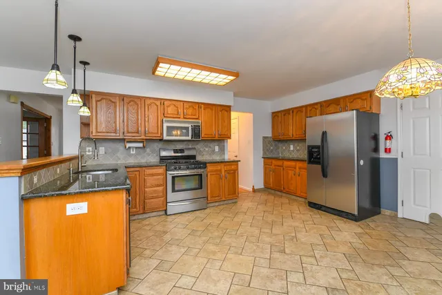 a kitchen with stainless steel appliances granite countertop a stove a sink dishwasher and a refrigerator