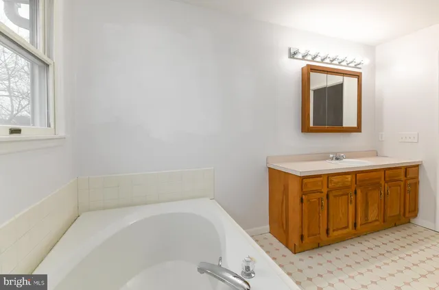 an empty room with windows and chandelier fan