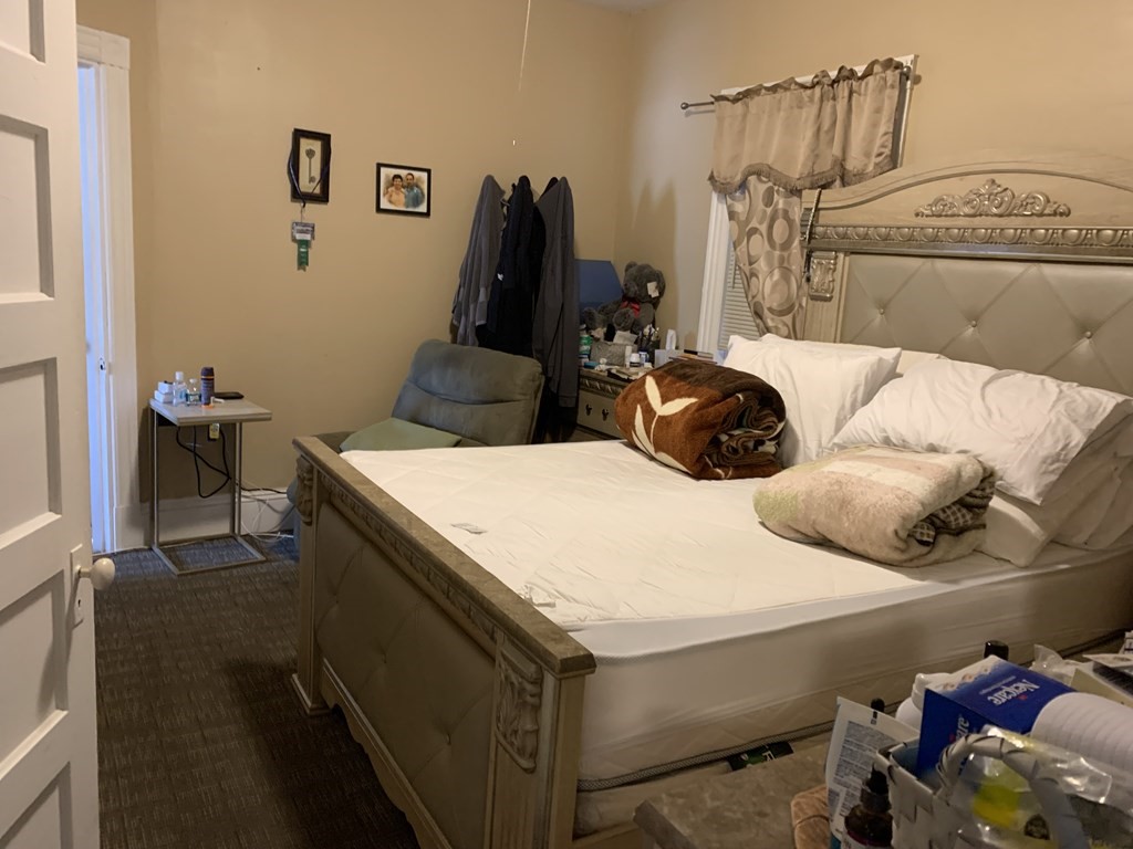 790 Broadway Everett, MA 02149 - Photo 30 of 39 a bedroom with a bed and wooden floor