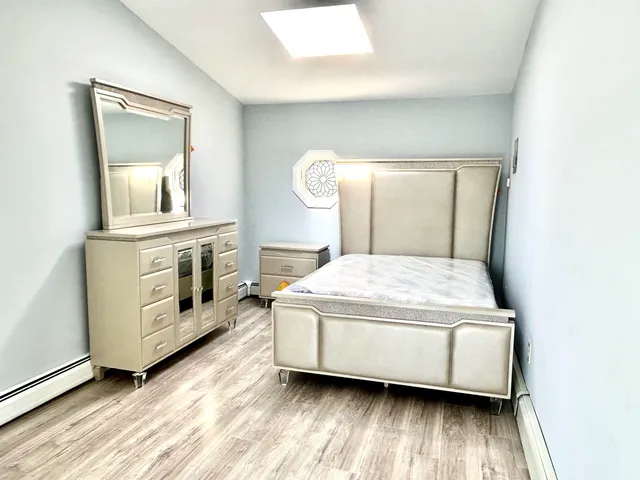 a bed sitting in a spacious bedroom next to a window