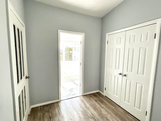 an empty room with wooden floor and a window