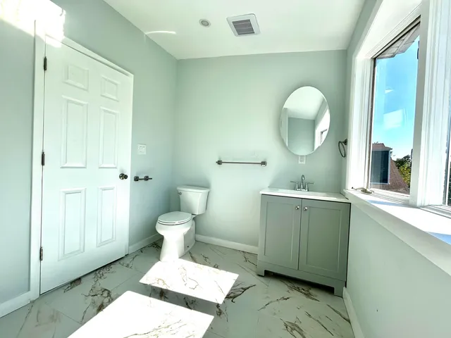 a bathroom with a toilet sink and mirror