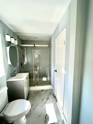 a white toilet sitting next to a bathroom sink
