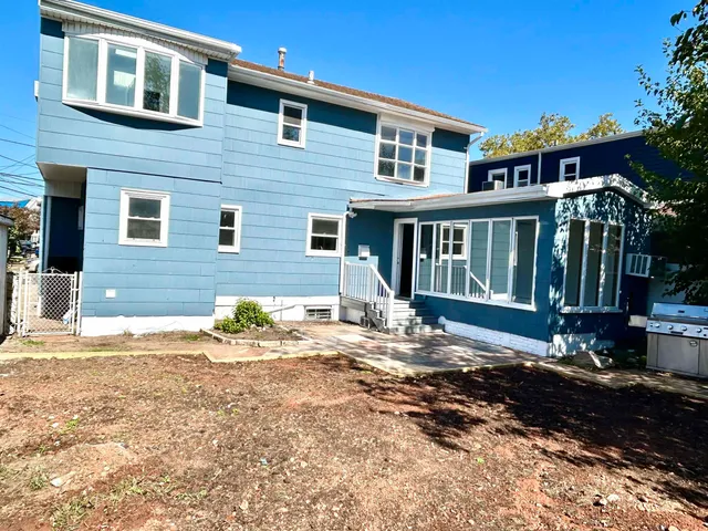 a view of a house with a yard and sitting area