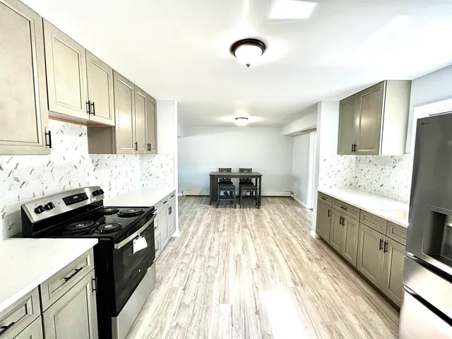 a kitchen with granite countertop a sink stove and cabinets