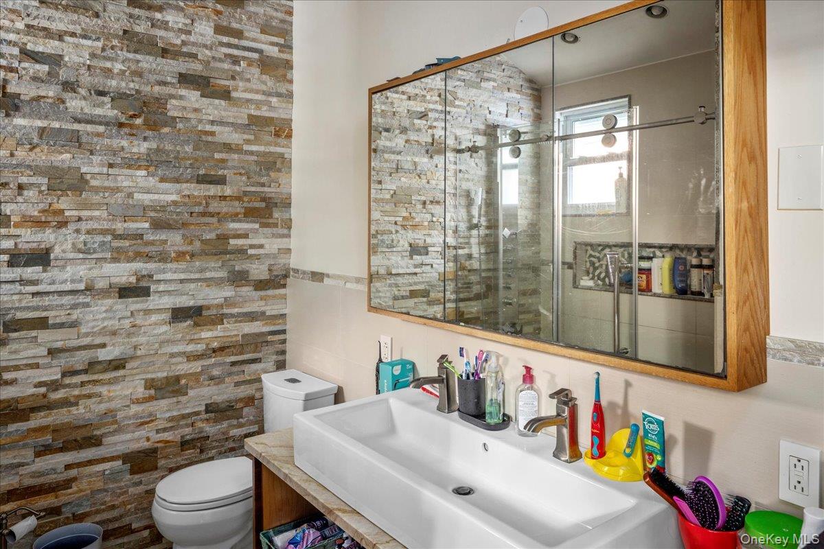 196-33 Foothill Avenue Queens, NY 11423 - Photo 13 of 34 a bathroom with a sink a toilet and a shower curtain