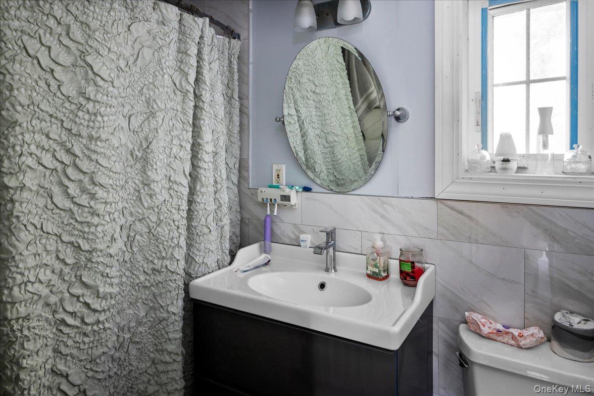 196-33 Foothill Avenue Queens, NY 11423 - Photo 19 of 34 a bathroom with a sink a mirror and a window