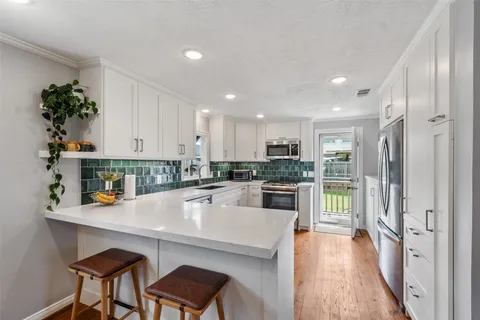 a kitchen with white cabinets and refrigerator