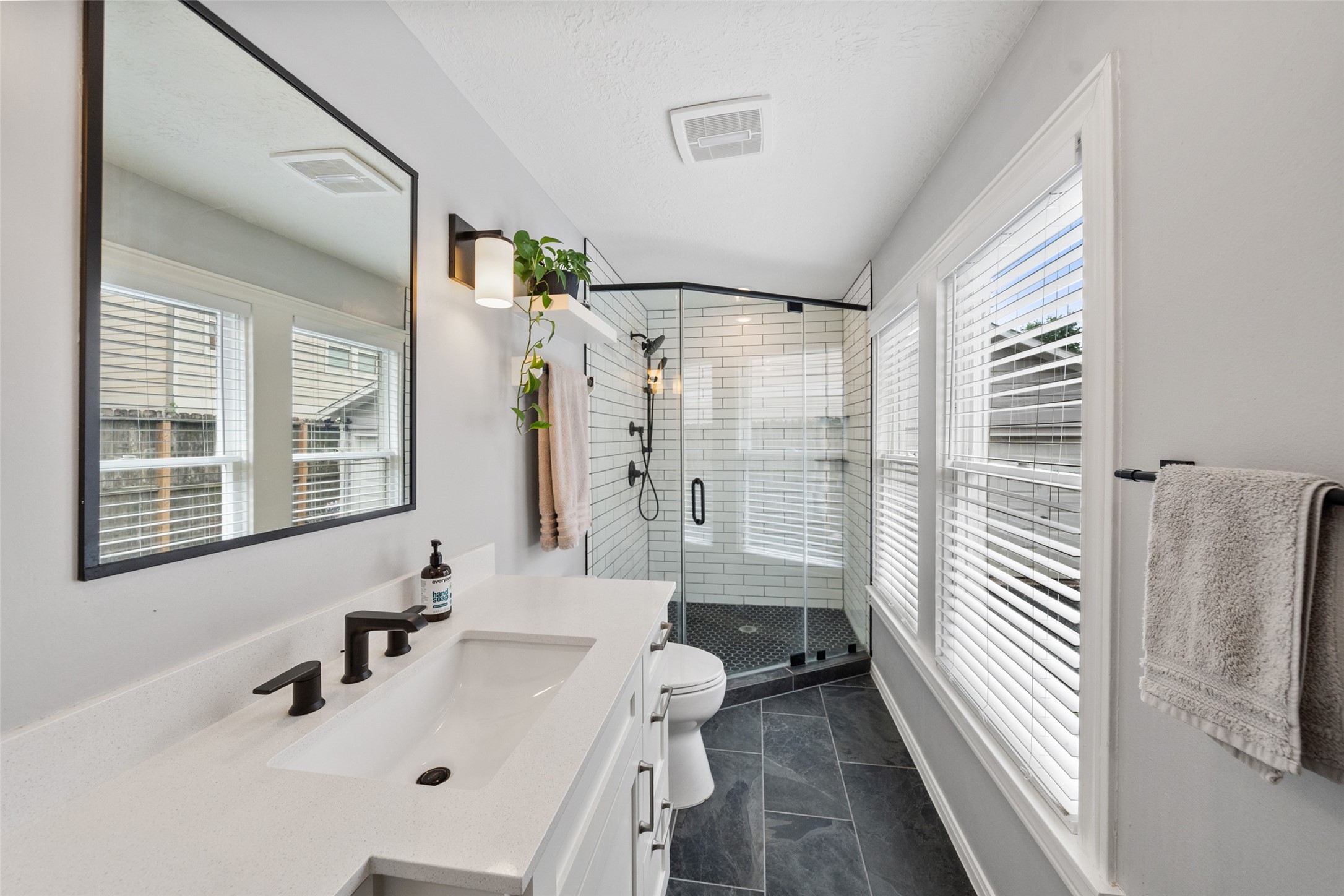 1510 Alexander Street Houston, TX 77008 - Photo 10 of 18 Frameless glass shower, subway tile, matte black fixtures, slate tile floors, and quartz vanity.
