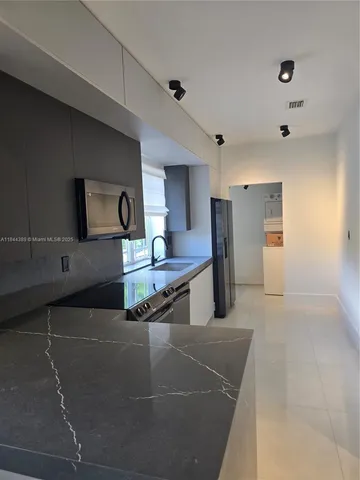 a kitchen with stainless steel appliances kitchen island sink refrigerator and stove