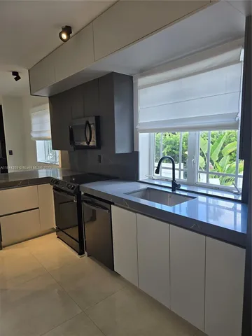 a kitchen with stainless steel appliances a sink stove and cabinets