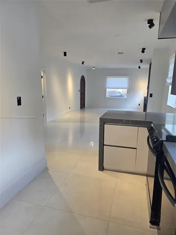 a view of a kitchen with a sink and a refrigerator