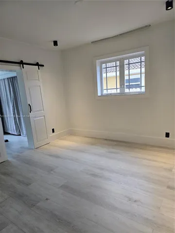 a view of a livingroom with wooden floor and a window
