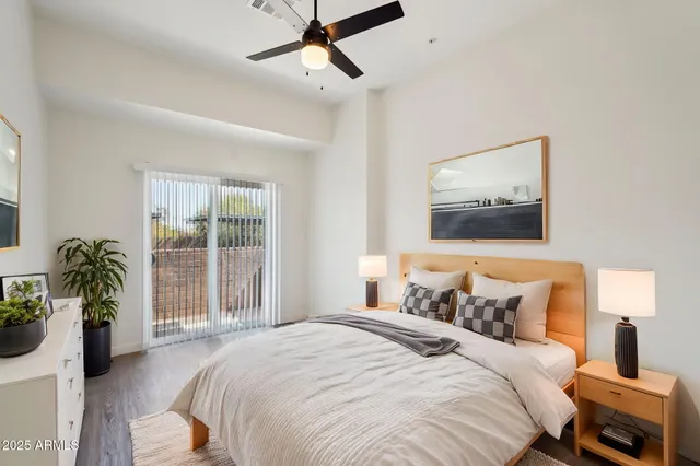 a bedroom with a balcony a bed and a painting on the wall