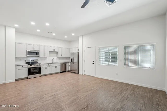 a large kitchen with stainless steel appliances granite countertop a stove a sink and a refrigerator