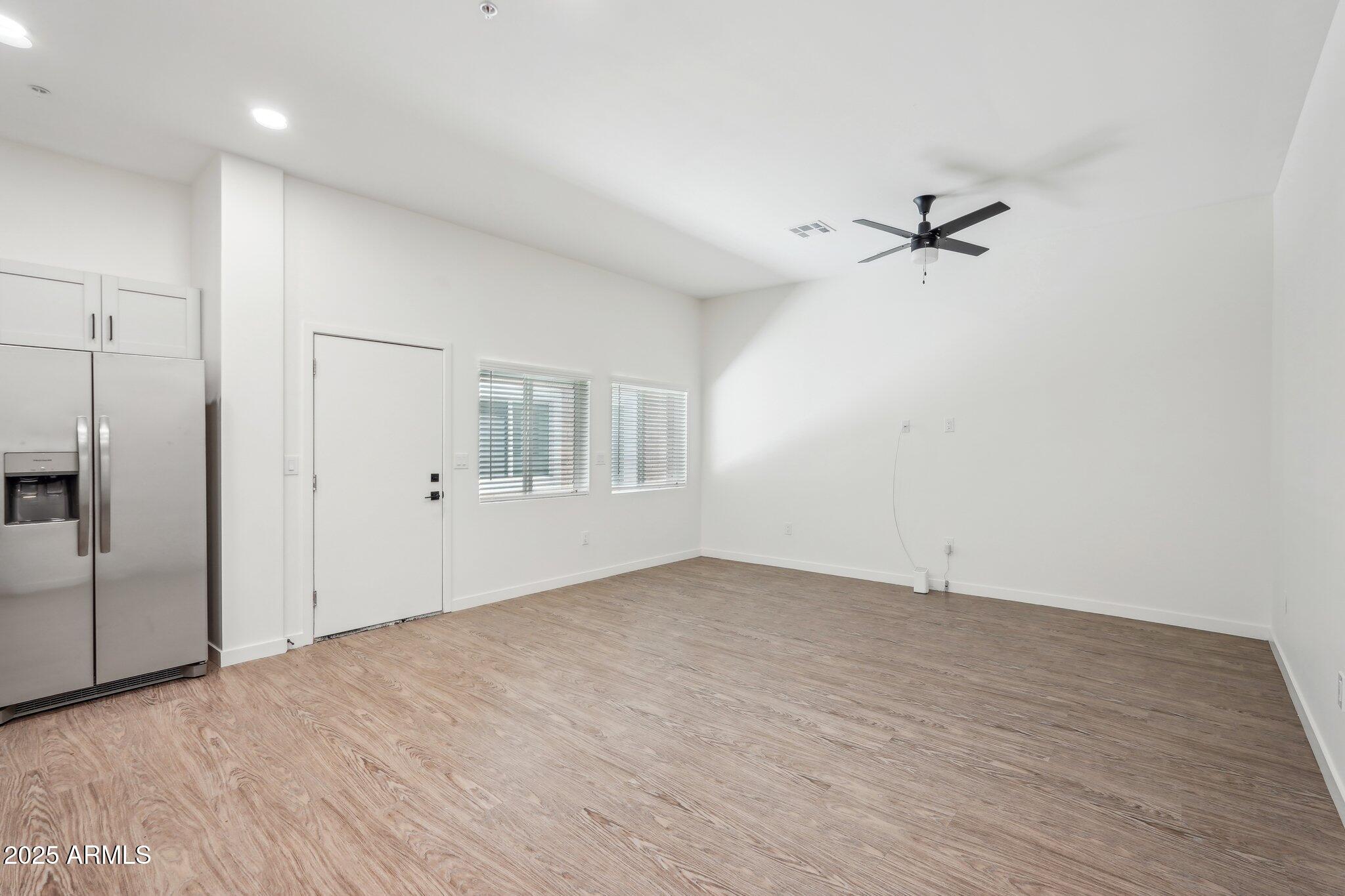 3031 West Northern Avenue, Unit 108 Phoenix, AZ 85051 - Photo 5 of 18 a view of empty room with wooden floor and fan