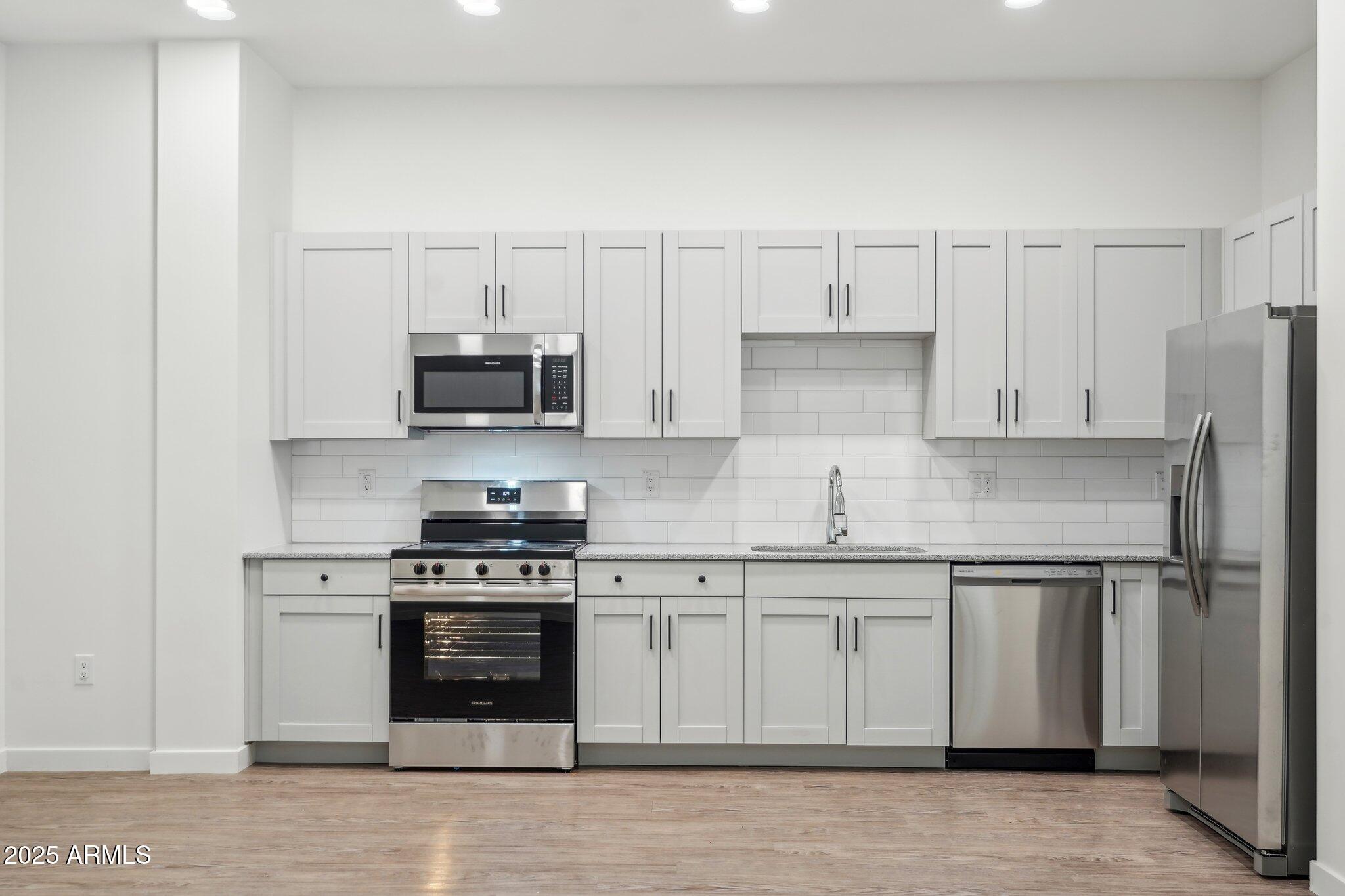 3031 West Northern Avenue, Unit 108 Phoenix, AZ 85051 - Photo 7 of 18 a kitchen with granite countertop white cabinets and stainless steel appliances