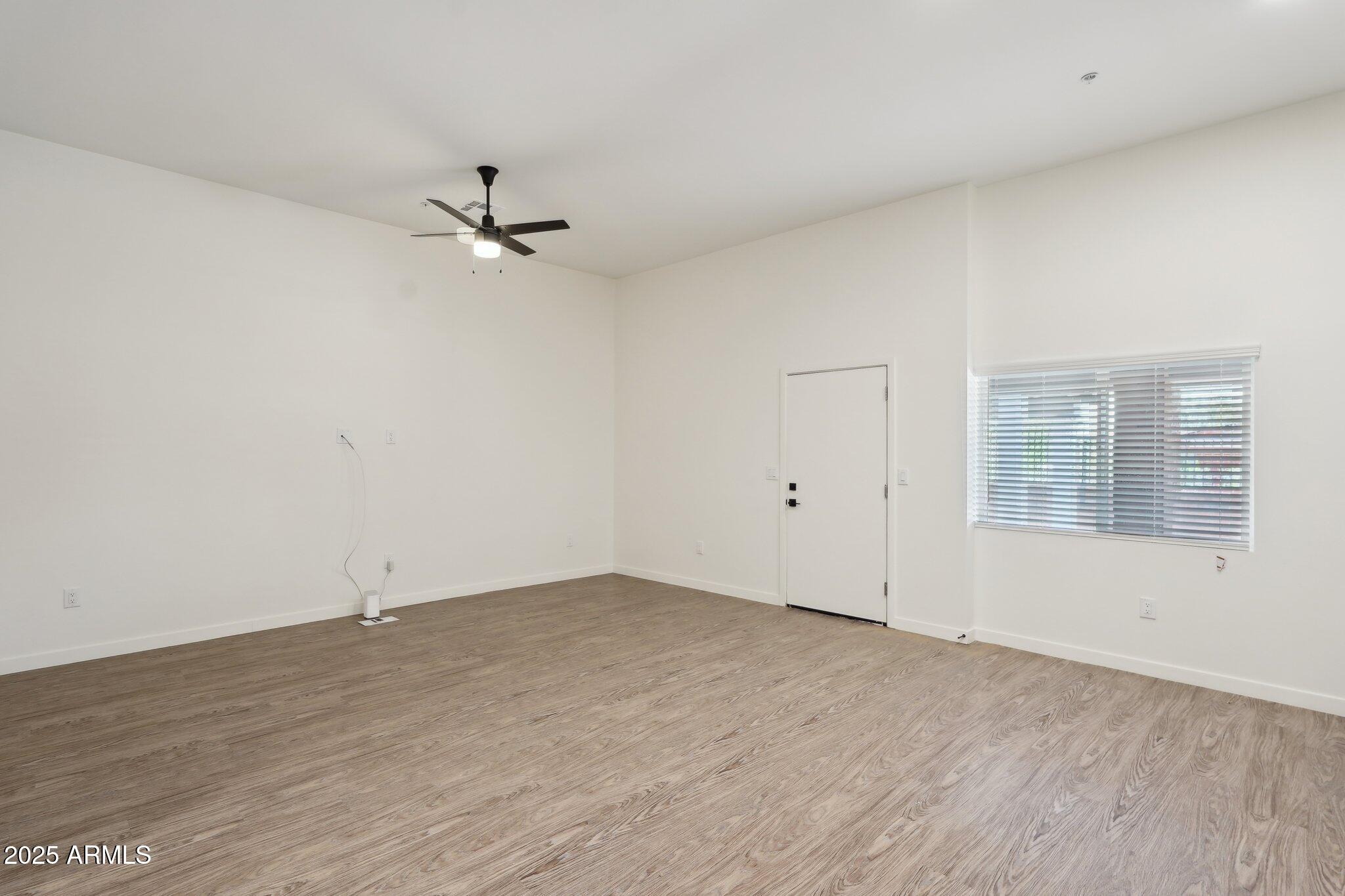 3031 West Northern Avenue, Unit 108 Phoenix, AZ 85051 - Photo 9 of 18 wooden floor in an empty room with a window