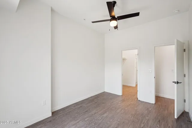 a view of a room with wooden floor and a ceiling fan