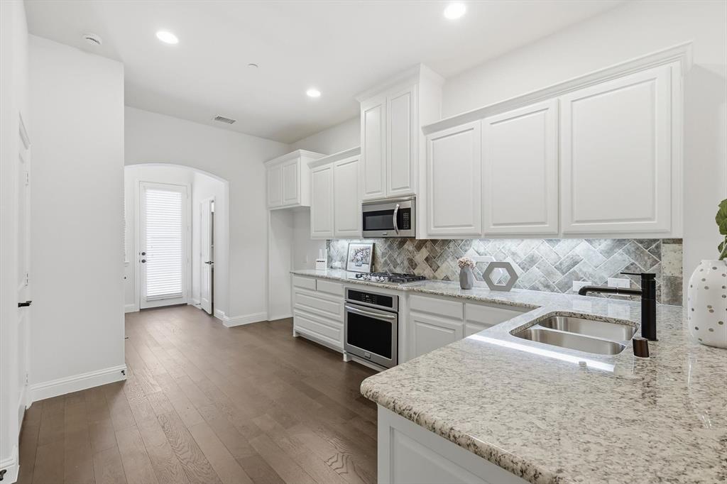 4642 Rhett Lane, Unit B Carrollton, TX 75010 - Photo 12 of 26 Kitchen with arched walkways, white cabinetry, tasteful backsplash, dark wood-style floors, and recessed lighting