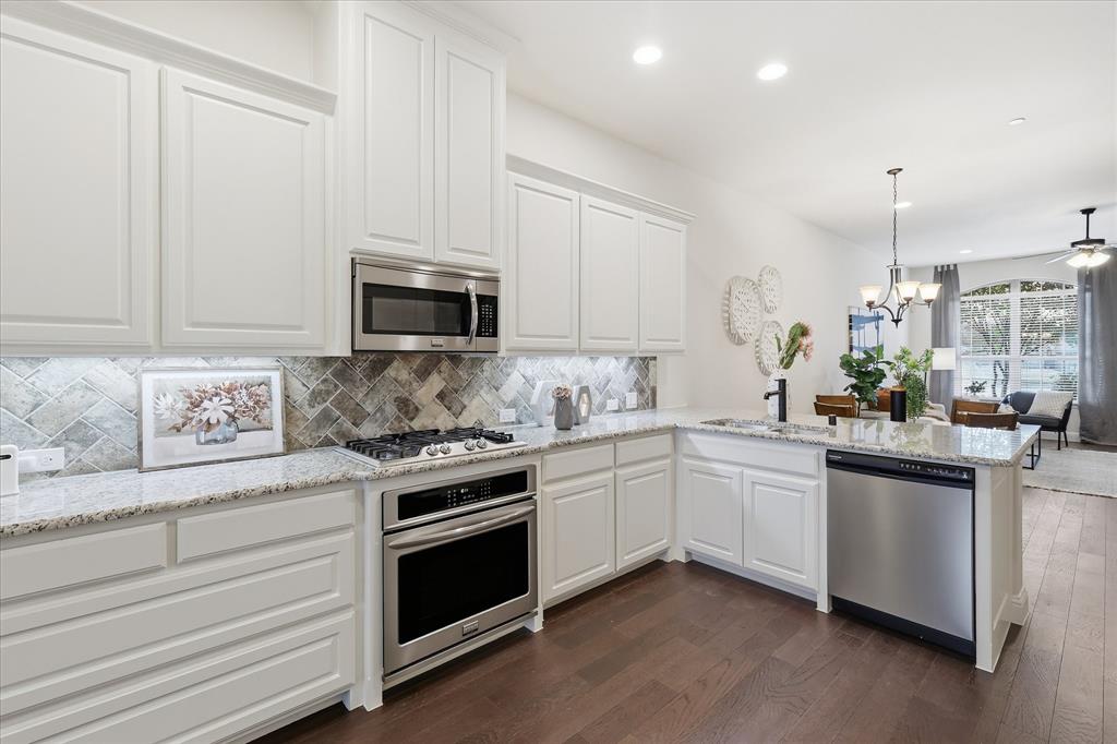 4642 Rhett Lane, Unit B Carrollton, TX 75010 - Photo 13 of 26 Kitchen featuring white cabinetry, light stone countertops, appliances with stainless steel finishes, decorative light fixtures, and recessed lighting