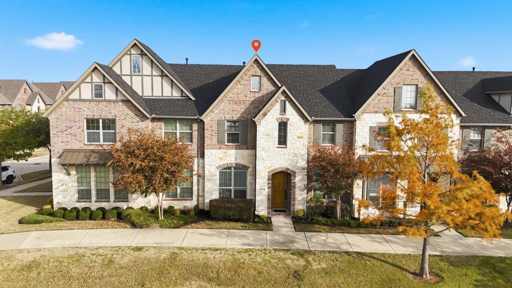 4642 Rhett Lane, Unit B Carrollton, TX 75010 - Photo 5 of 26 View of front of house featuring stone siding, brick siding, a shingled roof, and a front lawn