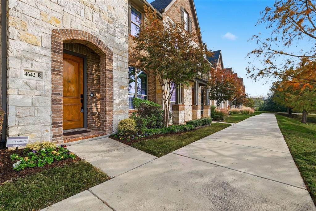 4642 Rhett Lane, Unit B Carrollton, TX 75010 - Photo 7 of 26 Property entrance featuring stone siding, brick siding, and a lawn