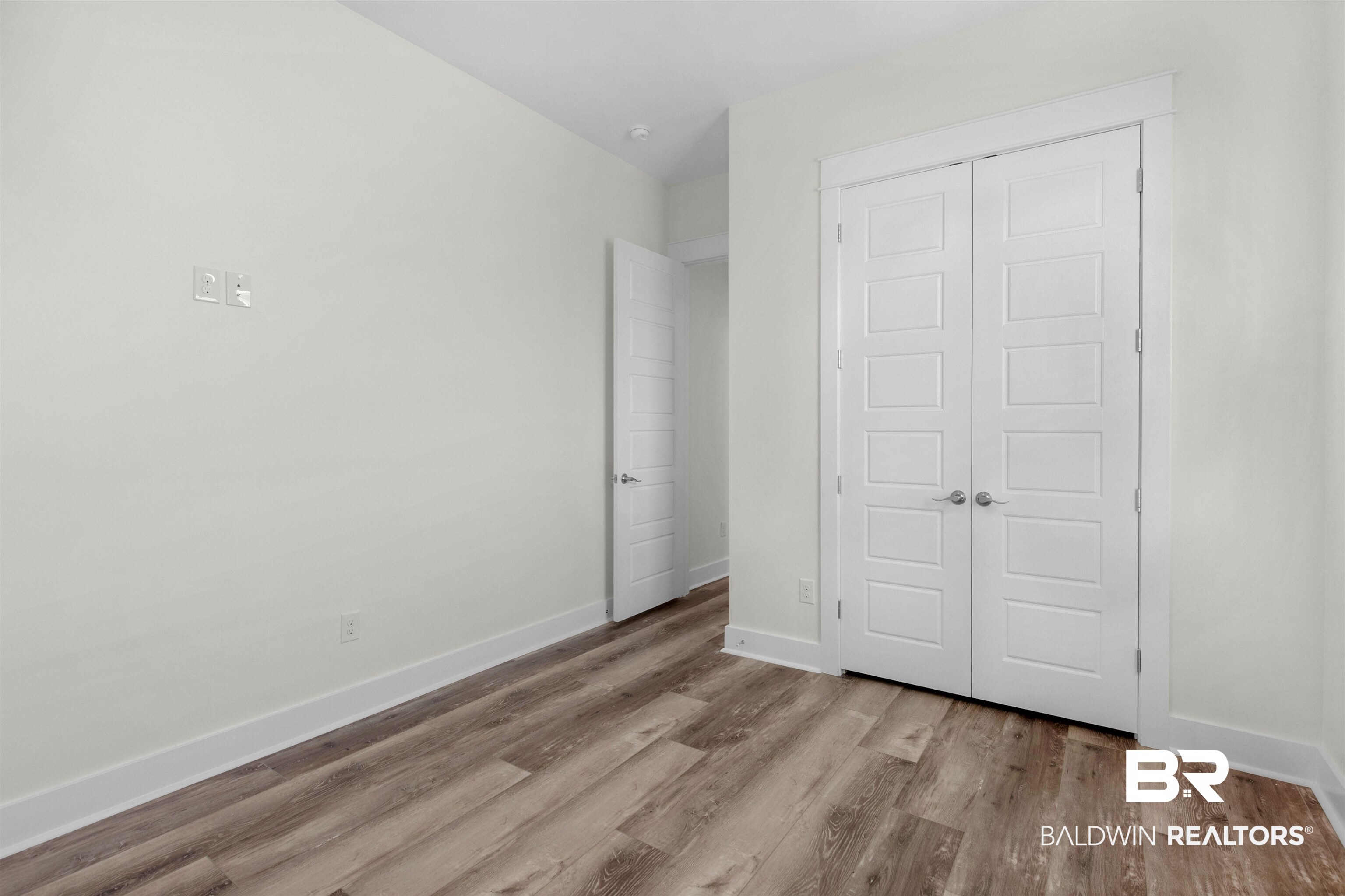 8069 Carmel Circle Foley, AL 36535 - Photo 14 of 23 Unfurnished bedroom featuring baseboards, a closet, and wood finished floors