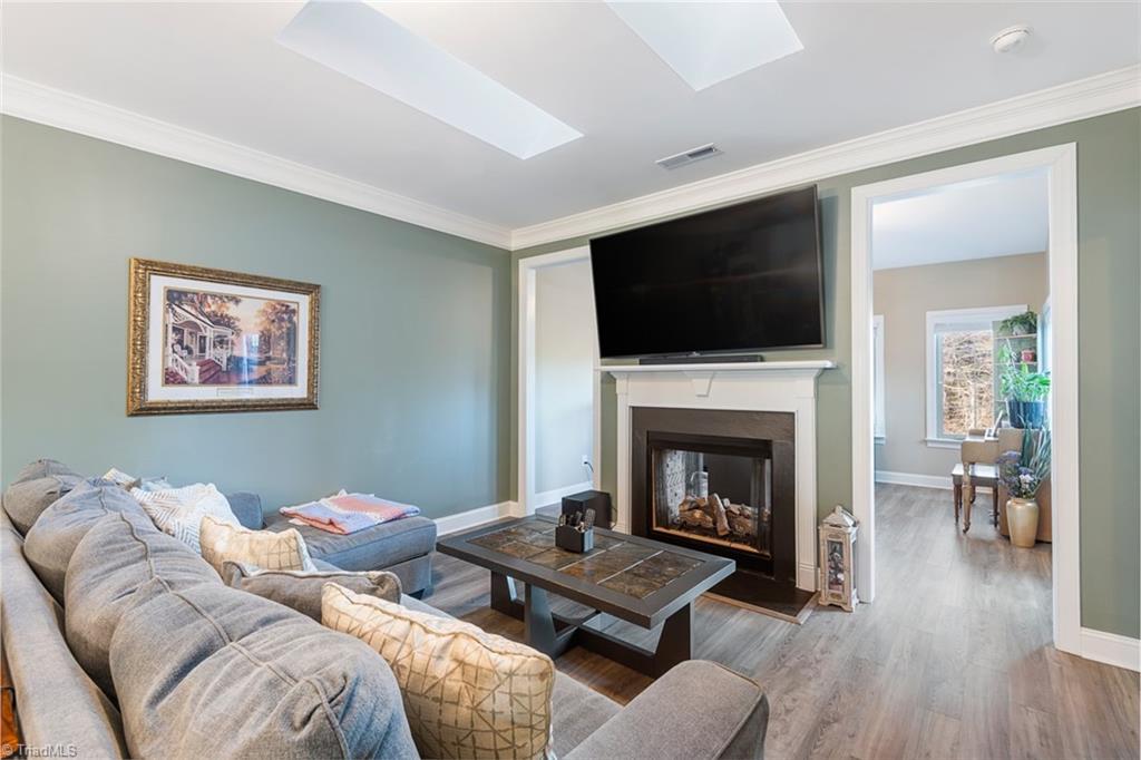 3805 Thistleberry Road High Point, NC 27265 - Photo 9 of 46 Dual sided gas log fireplace and skylights make this living space bright and cozy.