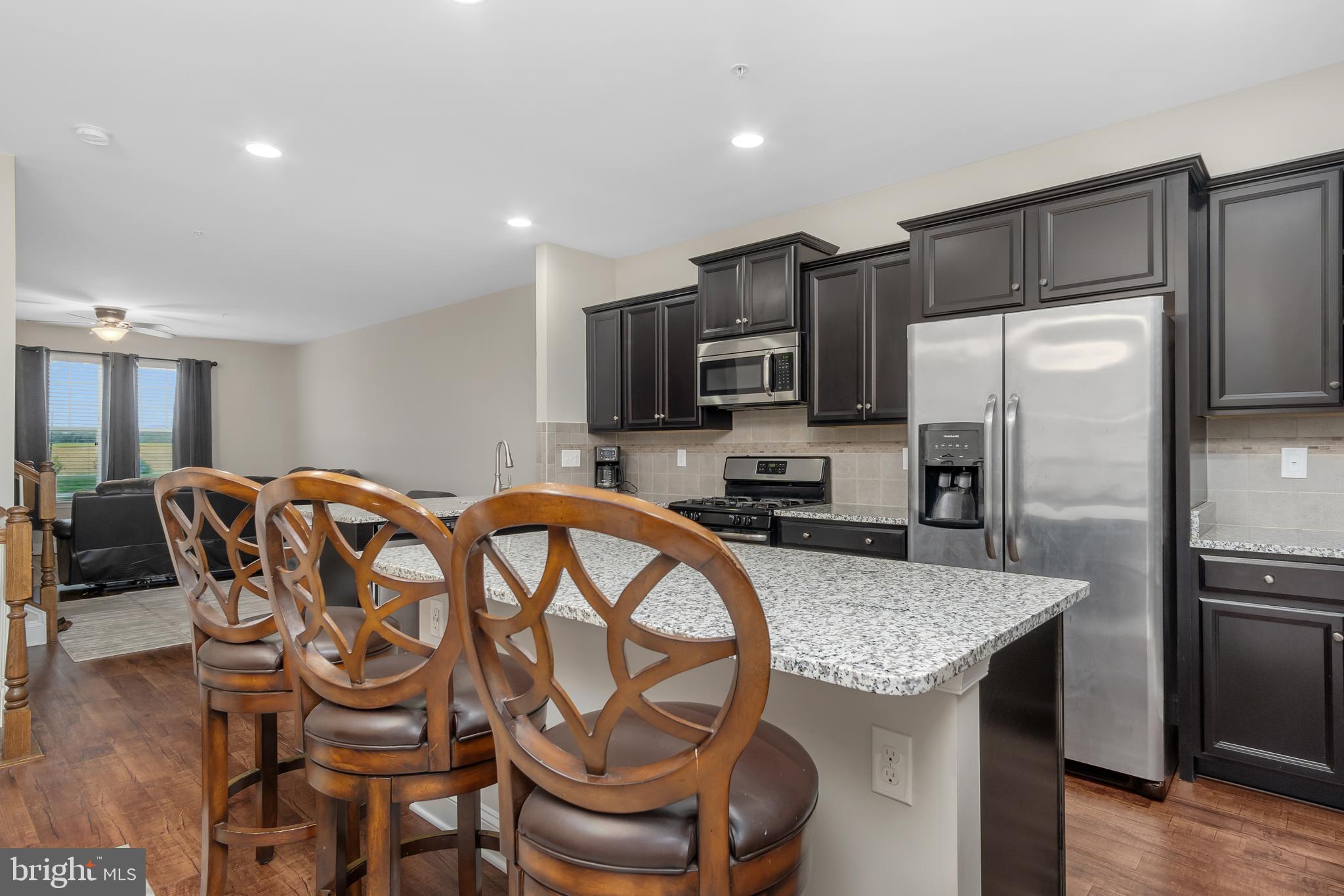 4615 Cambria Road Frederick, MD 21703 - Photo 7 of 33 a kitchen with granite countertop kitchen island stainless steel appliances a table and chairs