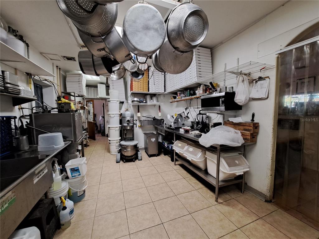 1600 Achieva Way Dunedin, FL 34698 - Photo 69 of 98 a kitchen with lots of appliances and a wooden floor