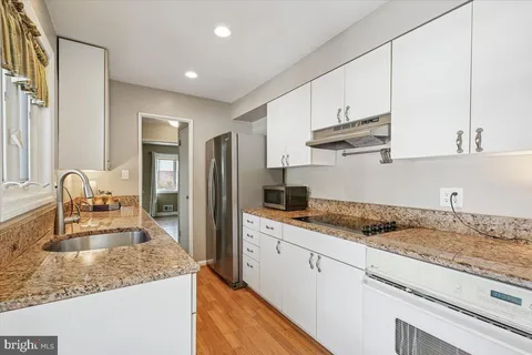 a kitchen with stainless steel appliances granite countertop a sink stove and cabinets