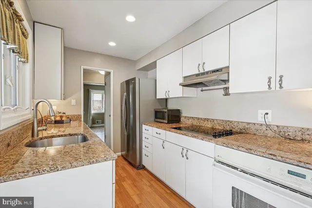 a kitchen with stainless steel appliances granite countertop a sink stove and cabinets