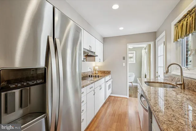 a kitchen with stainless steel appliances granite countertop a refrigerator and a stove