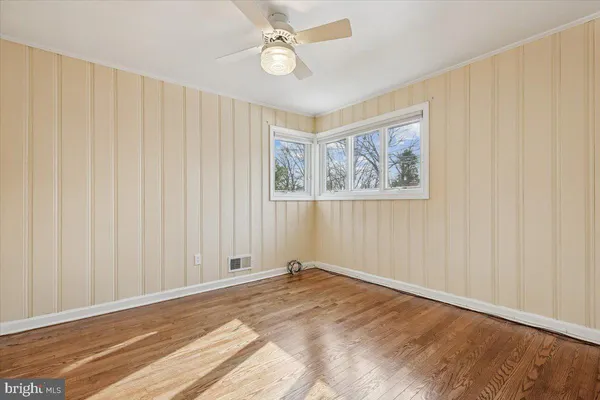a view of a livingroom with wooden floor and a ceiling fan