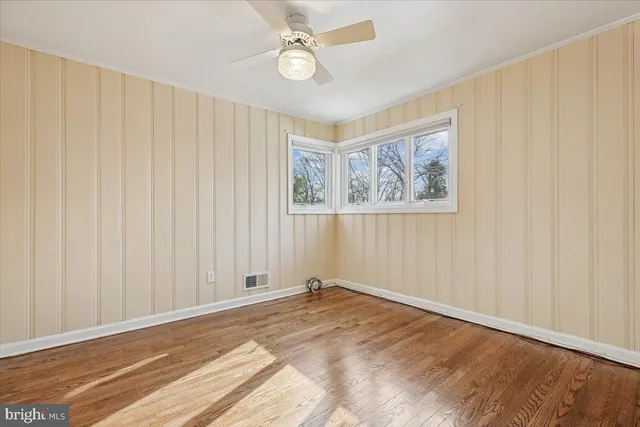 a view of a livingroom with wooden floor and a ceiling fan