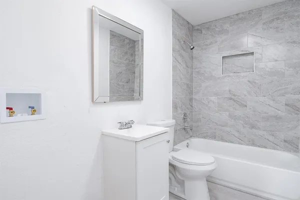a bathroom with a toilet sink and mirror