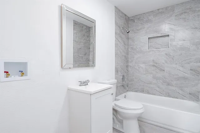 a bathroom with a toilet sink and mirror