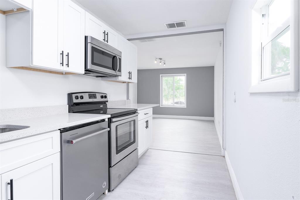 519 Williams Street Melbourne, FL 32901 - Photo 7 of 15 a kitchen with stainless steel appliances granite countertop a stove a microwave and a refrigerator